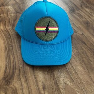 Unisex trucker hat by Friday Feelin’ featuring a bold rainbow patch design and b